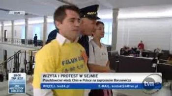 Nghị viện Ba Lan Một cảnh chụp màn hình từ TVP24 của Ba Lan về hai người biểu tình đang bị an ninh nghị viện dẫn đi (Ảnh chụp màn hình của TVP24)