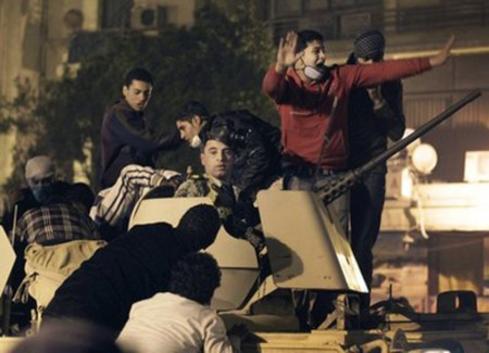 Một nhóm thanh niên chiếm xe bọc thép của quân đội tại Cairo hôm 28/1. Ảnh: AP.
