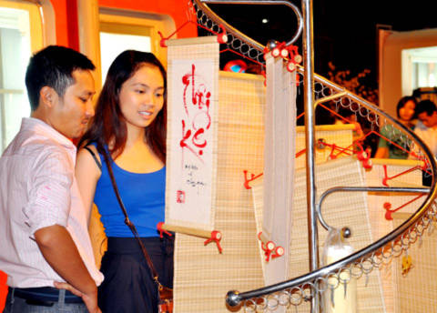 Đôi trai gái du xuân ngắm thư pháp