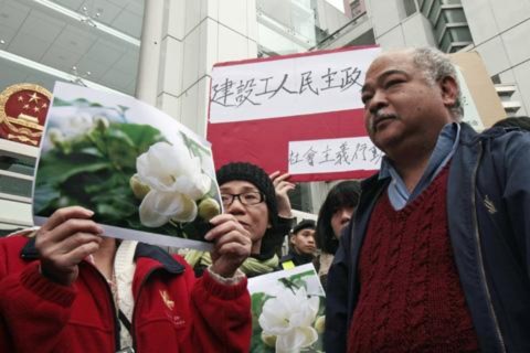 Người biểu tình giơ cao hình ảnh của hoa nhài để ủng hộ ’Cuộc cách mạng Hoa Nhài" ở Trung Ðông bên ngoài các văn phòng liên lạc của Trung Quốc ở Hồng Kông, ngày 20/2/2011