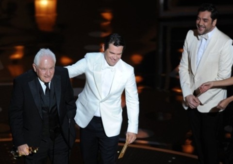 Tài tử No country for old men Javier Bardem (phải) nhìn đồng nghiệp Josh Broslin trao giải Oscar Kịch bản gốc xuất sắc cho David Seidler, biên kịch The King's Speech.