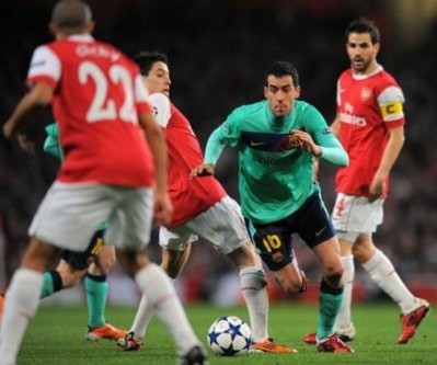 Tiền vệ Busquets (áo xanh, bên phải) trong vòng vây của Arsenal.
