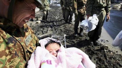 Cô bé 4 tháng tuổi trong tay một binh sĩ ở Nhật. Ảnh: AP.