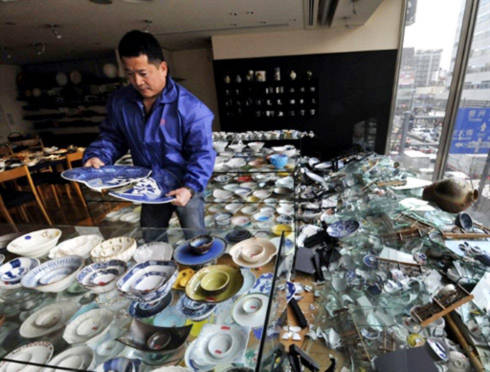 Chủ một cửa hàng gốm sứ tại Tokyo đang xem xét thiệt hại sau trận động đất. Ảnh: AFP