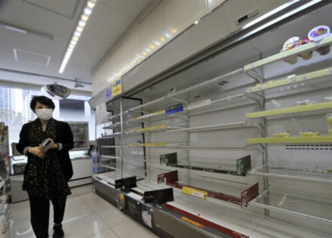 Một phụ nữ đi qua giá đề đồ trống trơn tại một siêu thị ở Tokyo. Ảnh: AFP.