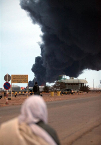 Lửa khói bốc lên từ một nhà máy lọc dầu ở thành phố Ras Lanuf khi quân đội chính phủ giao tranh với phe nổi dậy Libya. Ảnh: AFP