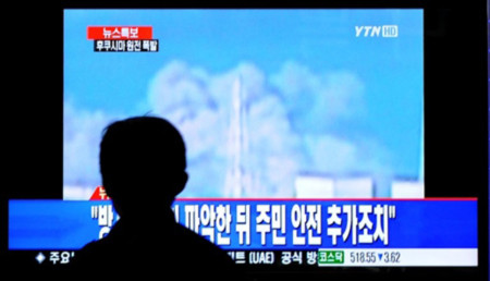 Một người dân Hàn Quốc xem cảnh tượng vụ nổ tại nhà máy điện hạt nhân Fukushima I tại Nhật Bản trong ga tàu điện ngầm tại thành phố Seuol hôm 12/3. Ảnh: AFP.