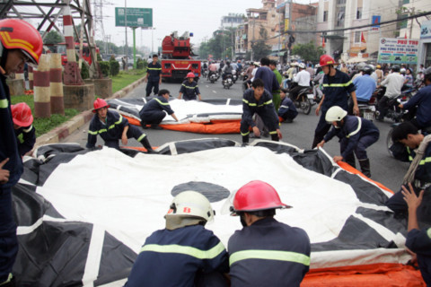 Lực lượng cứu hộ triển khai căng nệm hơi phía dưới, trừ trường hợp thanh niên nhảy xuống. Ảnh: An Nhơn.