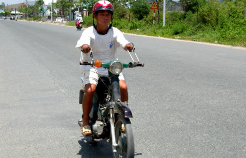 Ông Nghĩa cụt hai tay vẫn lái xe ào ào trên phố. Ảnh: Thiên Phước