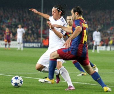 Ozil (bên trái) tranh bóng với Mascherano của Barca trong trận bán kết Champions League.