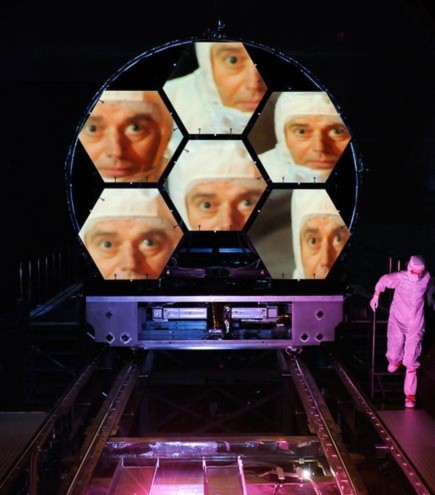 Hình ảnh khuôn mặt của giáo sư Mark Clampin phản chiếu trên những tấm kính của kính thiên văn vũ trụ James Webb được đặt tại Trung tâm vũ trụ Marshall ở Alabama.  Kính thiên văn có đường kính rộng 6,5m này được xây dựng để thay thế cho kính thiên văn Hubble. Dự kiến, kính thiên văn vũ trụ James Webb sẽ chính thức hoạt động vào năm 2014.