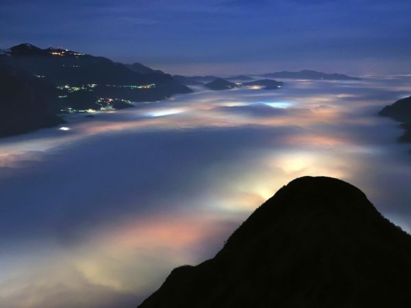 Những làn mây bao phủ trên bầu thung lung Lago di Olginate, Italy. Tô sắc cho những đám mây trắng là ánh đèn của thị trấn và ngôi làng nhỏ trong đêm. - Ảnh: Stefano Anghileri.