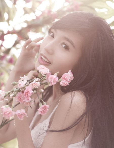 Elly Trần e ấp bên hoa.