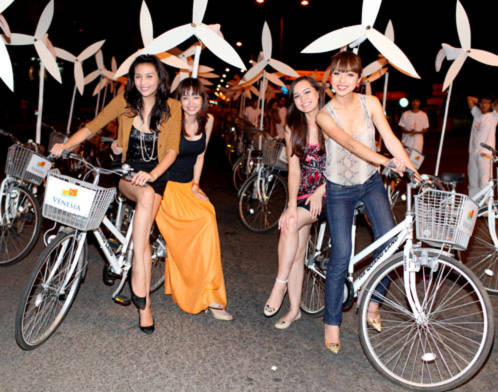 Hoàng Yến chở Trúc Diễm (trái) và Jennifer Phạm đèo Thúy Vy Victoria trên hai chiếc đạp đi vòng quanh phố khuya Nha Trang mùa lễ hội.