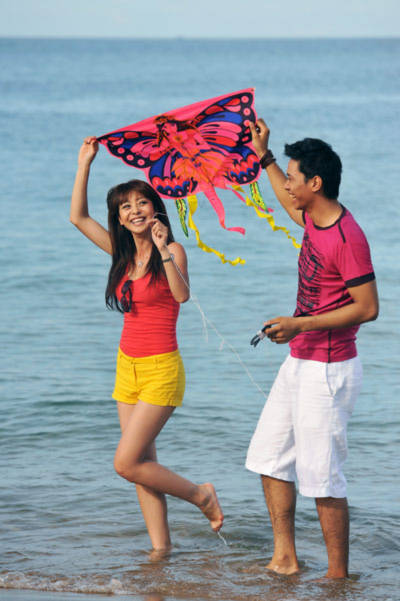 Hai người lúng túng tìm cách thả diều bay lên cao.