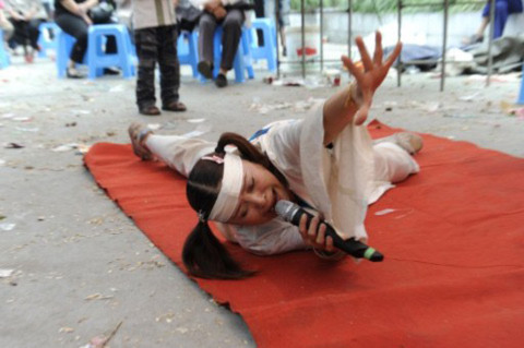 Hu Xinglian khóc trong đám tang của Ling Zhicai. Ảnh: AFP.