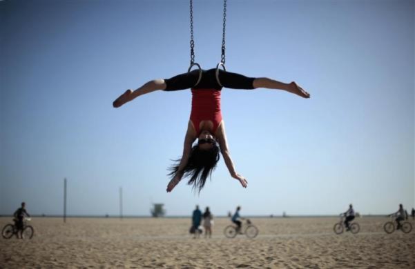 Một cô gái tập thể dục vòng treo trên một bãi biển ở Santa Monica, California, Mỹ.