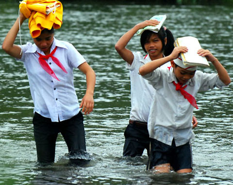 Đội áo lạnh, sách vở trên đầu trên đường vượt sông.