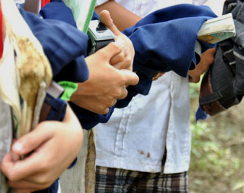 Nam sinh ôm chặt sách vở và quần dài vượt sông.
