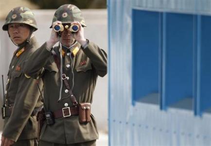 North Korean soldiers look to the South as they patrol at Panmunjom