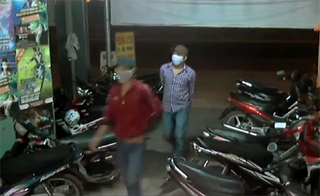 Hai tên cướp bịt khẩu trang kín mít đi vào tiệm internet. (Ảnh cắt từ clip)