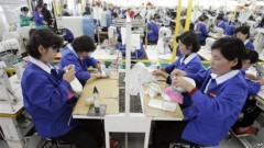 Công nhân Bắc Triều Tiên làm việc tại một nhà máy sản xuất giày của Nam Triều Tiên trong khu công nghiệp Kaesong. Khu này tuyển dụng 53.000 lao động Bắc Triều Tiên. Chính phủ miền Bắc lấy đi phần lớn khoản tiền lương khoảng 110 đôla/tháng của các công nhân này.