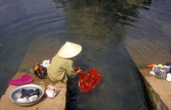 Một phụ nữ Việt Nam giặt quần áo bên dòng sông Mekong AFP photo