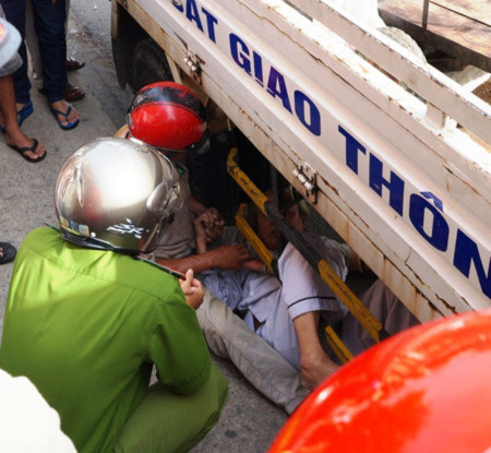 Cụ Ninh bức xúc chui vào gầm xe CSGT phản đối sự việc, được công an, người nhà vận động đưa cụ ra ngoài.