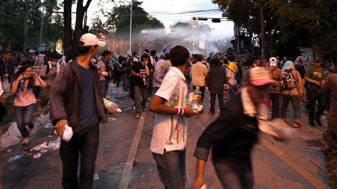 Người biểu tình bỏ chạy khi cảnh sát bắn hơi cay, xịt vòi rồng ở gần phủ thủ tướng Thái Lan - Ảnh: V.Phương