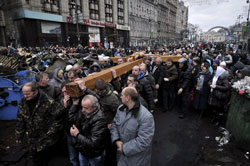 Người dân Ukraine mang một cây thánh giá lớn tưởng niệm cho các nạn nhân của cuộc xung đột gần đây giữa người biểu tình và cảnh sát tại Kiev. Ảnh chụp hôm 24/2/2014. AFP photo