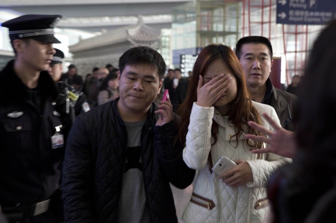 Một người phụ nữ rơi nước mắt tại sảnh chờ của Sân Bay Quốc tế Bắc Kinh, Trung Quốc, hôm thứ 7, sau khi rộ lên tin tức liên quan đến chiếc máy bay Boeing của hãng hàng không Malaysia Airlines Mất tích trong hành trình từ Kualar Lumpur đến Bắc Kinh. (AP Photo/Ng Han Guan)