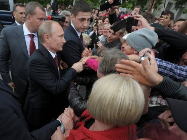 Tổng thống Vladimir Putin (trái) gặp gỡ người dân địa phương trong chuyến thăm bán đảo Crimea. (Nguồn: AFP/TTXVN)