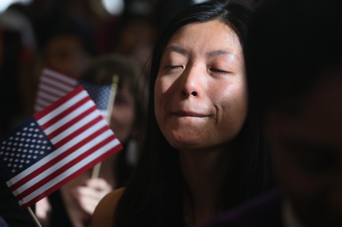 Người Trung Quốc nhập cư, đang làm việc ở Quỹ Phòng hộ, Yi Shu kìm những dòng nước mắt khi tuyên thệ công dân ở lễ nhập tịch tại New York, ngày 9 tháng 4 năm 2013 (John Moore/ Getty Images)
