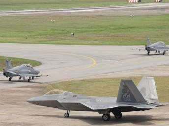 Một chiến đấu cơ tàng hình F-22 Raptor của Mỹ đang theo sau hai chiếc BAE Hawk của Malaysia trên phi đạo nhân cuộc tập trận Cope Taufan 2014. Ảnh chụp tại căn cứ không quân Butterworth, Malaysia ngày 11/06/2014. Pacific Air Forces