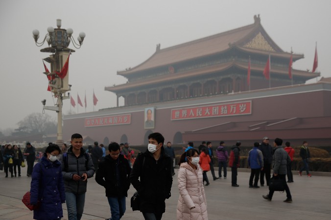 Du khách Trung Quốc đeo khẩu trang trên Quảng trường Thiên An Môn trong khoảng thời gian ô nhiễm nặng nề vào ngày 25/4/2014 ở Bắc Kinh, Trung Quốc. Các nhà lãnh đạo hàng đầu Trung Quốc sẽ tập trung lại trong phiên họp toàn thể lần thứ 4 Ban Chấp hành Trung ương Đảng Cộng Sản Trung Quốc lần thứ 18 từ ngày 20/10 đến ngày 23/10/2014. (Lintao Zhang/Getty Images)