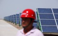 Một công nhân Trung Quốc đi bộ trong các mô-đun pin mặt trời của một dự án năng lượng quang điện kết nối với lưới điện có công suất 100MW mới được lắp đặt, vào ngày 21/7/2010 ở Đôn Hoàng, tỉnh Cam Túc phía Tây Bắc Trung Quốc. (Ảnh: Feng Li/Getty Images).