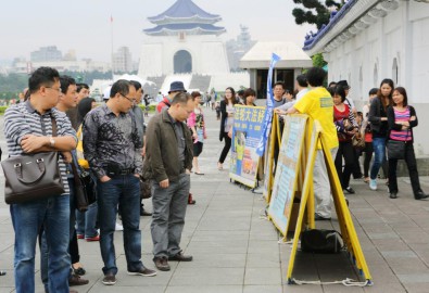 Du khách Trung Quốc dừng lại và chăm chú xem những thông tin về Pháp Luân Công