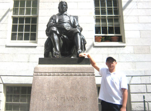 Hoàng Minh Tuệ bên tượng đài John Harvard tại Đại học Harvard (bang Massachusetts, Mỹ) trong chuyến du học bổng ASSIST năm 2013