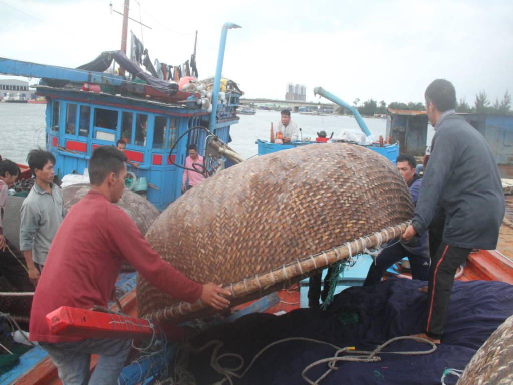 Các ngư dân trên tàu cá của ông Huỳnh Bi giúp dọn dẹp tàu cá bị nạn - Ảnh: Đoàn Cường