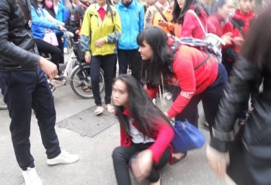 Nữ sinh khối 10 trường THPT Bùi Thị Xuân bị đánh ngã xuống nền đất (ảnh: Lê Công Doanh).- danviet