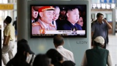 Hành hánh Hàn Quốc xem bản tin về việc đào thoát của tướng quân đội Triều Tiên Ri Yong-ho trên màn hình ở ga tàu Seoul, Hàn Quốc, 17/7, 2012. (Ảnh: AP)