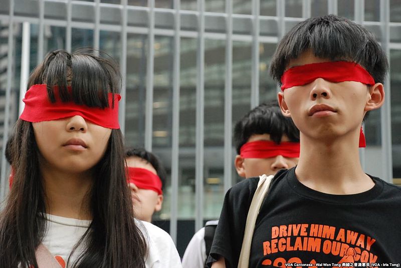 Trong buổi tuyên bố bãi khóa tháng 9/2014, Hoàng Chi Phong bịt mắt bằng khăn đỏ, tượng trưng cho chế độ đỏ của Trung Quốc làm mù mắt sinh viên. (Ảnh: VOA)