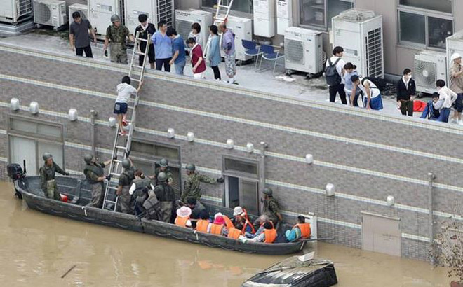 Các lực lượng phòng vệ đưa người dân ra khỏi vùng lụt tại tỉnh Okayama. Ảnh: Kyodo.