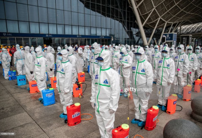 TOPSHOT - Staff members line up at attention as they prepare to spray disinfectant at Wuhan Railway Station in Wuhan in China's central Hubei province on March 24, 2020. - China announced on March 24 that a lockdown would be lifted on more than 50 million people in central Hubei province where the COVID-19 coronavirus first emerged late last year. (Photo by STR / AFP) / China OUT (Photo by STR/AFP via Getty Images)